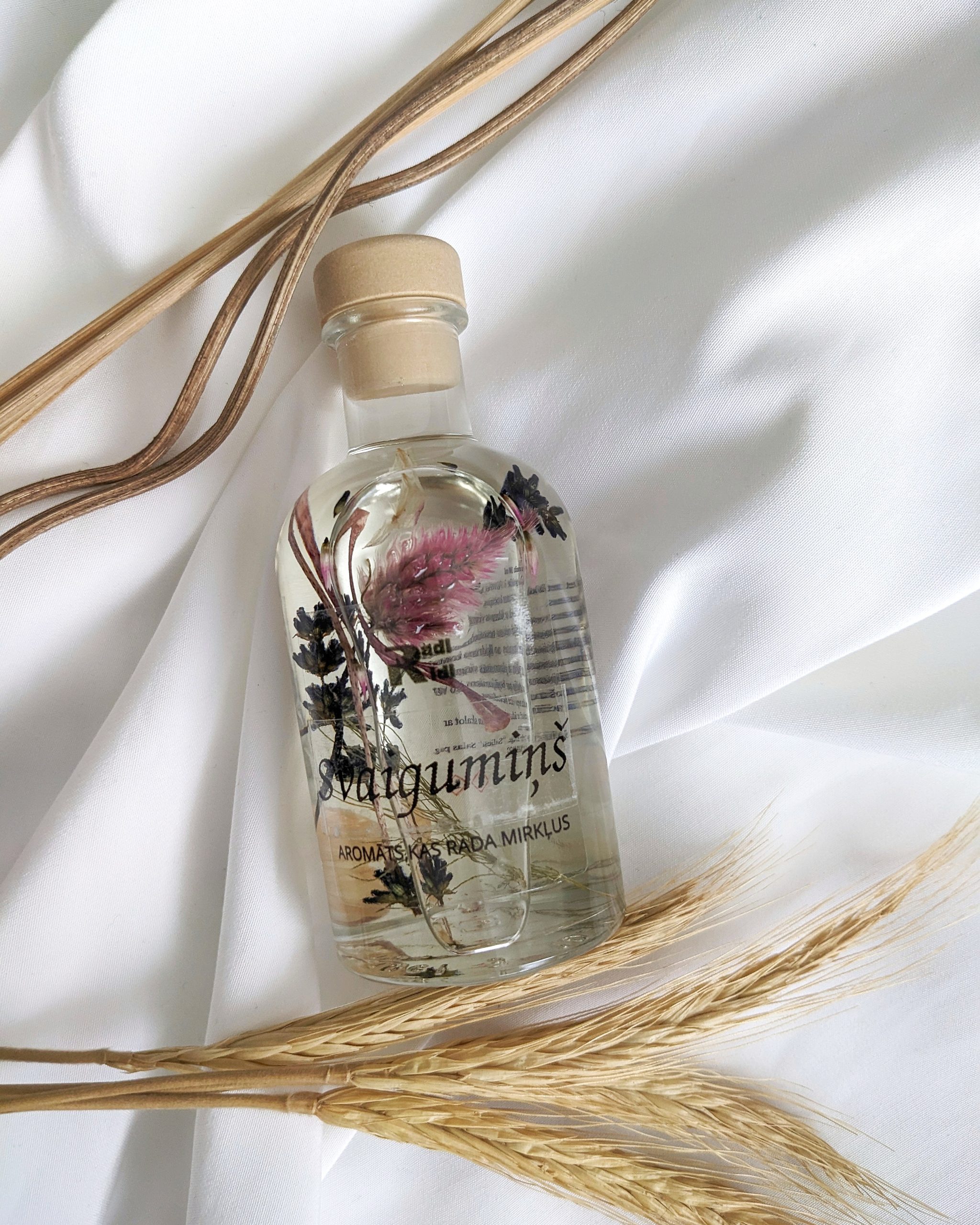 Mājas aromāts ar ziediem stikla pudelē un difuzora kociņiem, dabīgs istabas aromatizētājs patīkamam un ilgnoturīgam smaržam mājās
